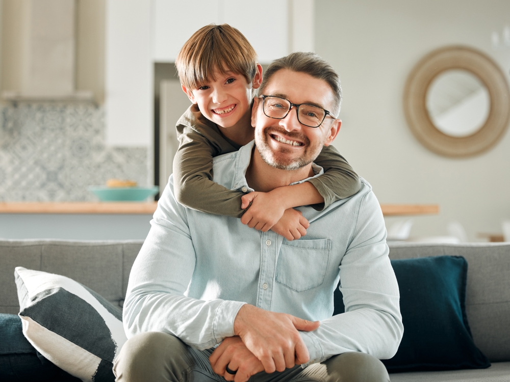A father and son smile together while wearing eyeglasses, emphasizing the importance of routine eye care and regular vision checkups for the entire family - Comprehensive Eye Exams